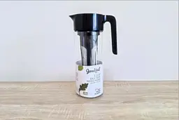 The Goodful cold brew coffee maker with a user guide leaflet rolled up inside.