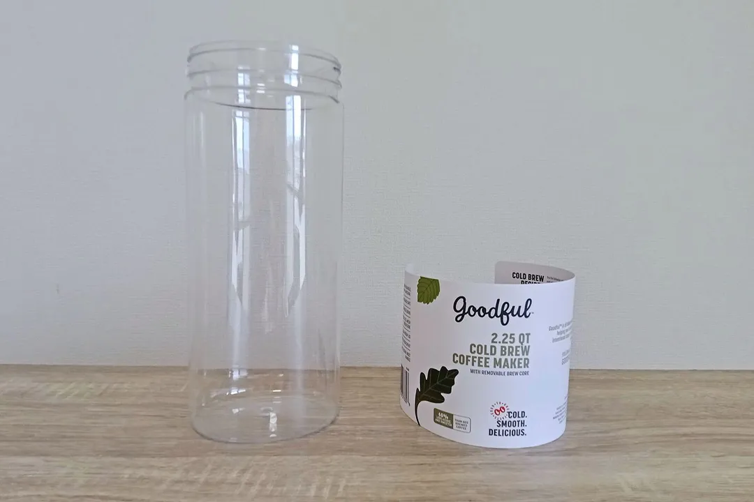 The plastic carafe of the Goodful cold brew coffee maker with the user guide insert standing to the right.
