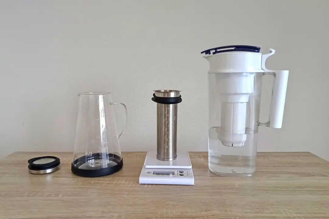 The Ovalware RJ3 cold brew coffee maker set up to brew with the filter on a scale and a carafe of filtered to the far right.