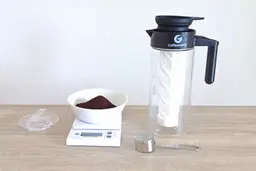 The Coffee Gator cold brew coffee maker set up for brewing with measured coffee grounds on a scale.
