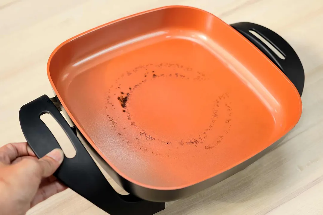 Burnt caramel on the surface of the Bella Non-Stick Electric Skillet 14607.