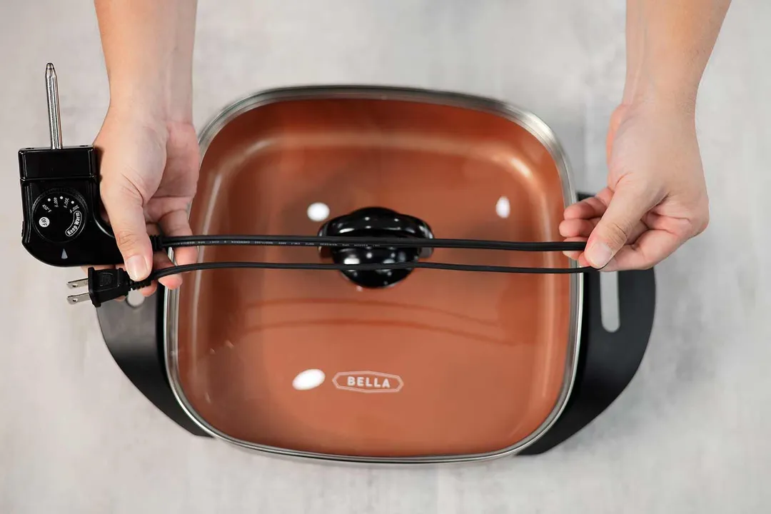 The flat two-prong power cord of the Bella Non-Stick Electric Skillet 14607 is 26.57 inches long.