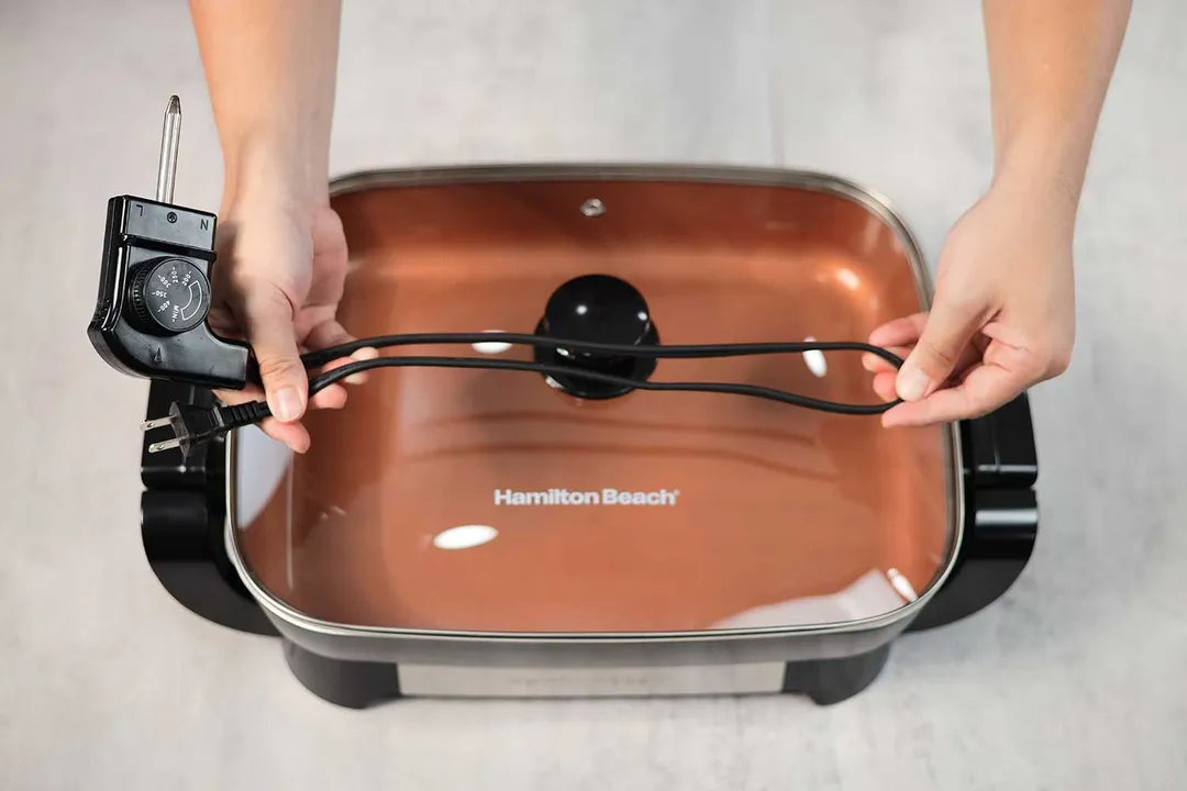 The flat two-prong power cord of the Hamilton Beach Ceramic Non-Stick Electric Skillet 38529K is 28.74 inches long.