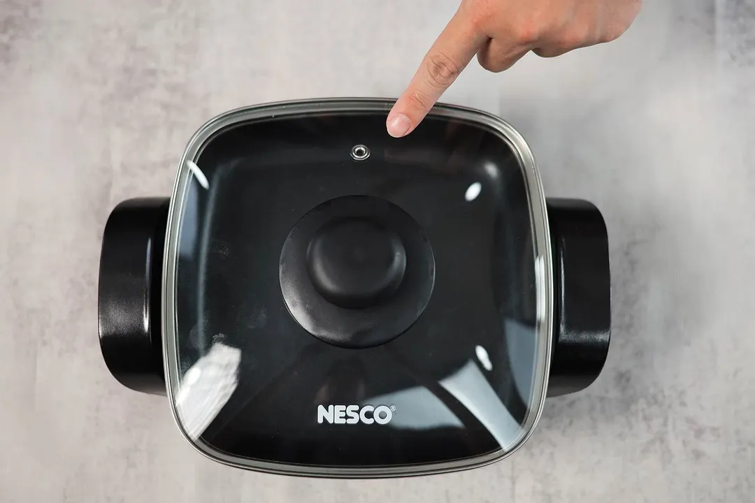 The tempered glass lid of the Nesco Non-Stick Electric Skillet ES-08 has a steam vent.