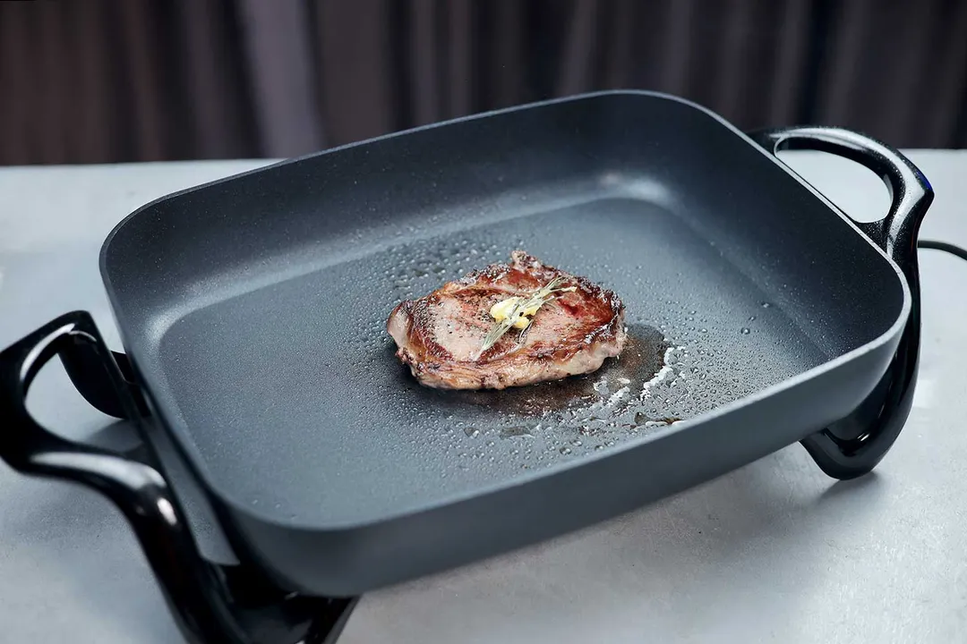 Searing a piece of steak with the Presto Electric Skillet 06852.