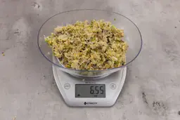 6.55 ounces of ounces of visible fish pin bones in mess of ground assorted scraps, on digital scale, on granite-looking top