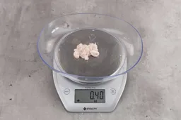 0.4 ounces of shredded soft tissue, on digital scale, on granite-looking table.