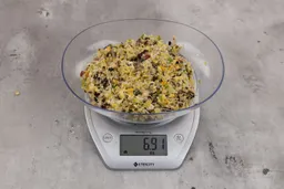 6.91 ounces of fish pin bones in mess of assorted scraps from garbage disposal on digital scale on granite-looking top.