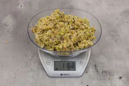 11.68 ounces of assorted scraps from garbage disposal on digital scale on granite-looking top.