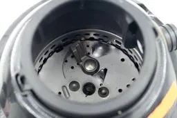 Top view through collar of Disposall GFC720N GE garbage disposal into chamber after testing, looking at layout of grinding components, highlighting swivel impellers, flywheel, and grater/grinder ring.