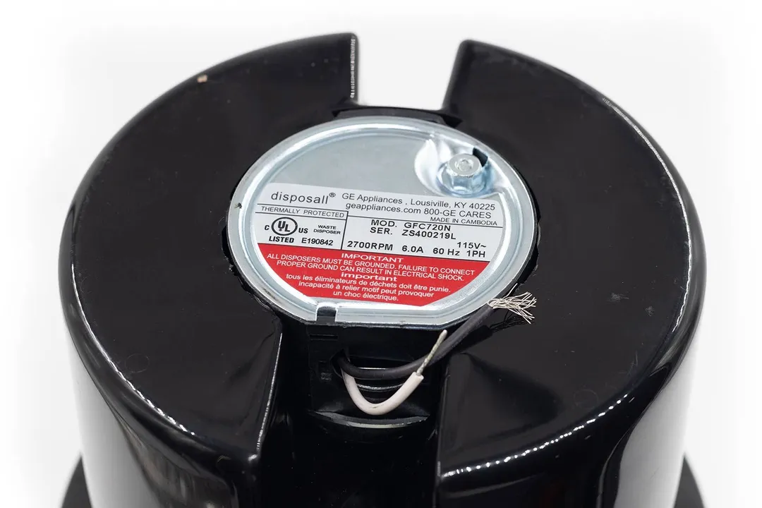 Bottom view of GE Disposall GFC720N 3/4-hp non-corded garbage disposal with two pre-cut electrical wires. Information sticker showing model number, serial number, rotational velocity, power ratings, etc.