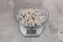 5.67 ounces of ground fish scraps from garbage disposal, displayed on digital scale, placed on granite-looking table. Visible pin bones among mess of raw fibrous tissue.5.67 ounces of ground fish scraps from garbage disposal, displayed on digital scale, placed on granite-looking table. Visible pin bones among mess of raw fibrous tissue.