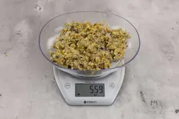 5.59 ounces of ground products from a garbage disposal, displayed on digital scale, placed on a granite-looking table. Visible fish pin bones in mess of assorted scraps.5.59 ounces of ground products from a garbage disposal, displayed on digital scale, placed on a granite-looking table. Visible fish pin bones in mess of assorted scraps.