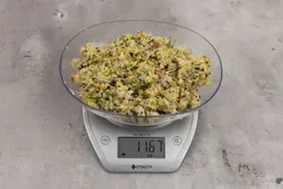 11.67 ounces of fish pin bones in mess of assorted scraps from garbage disposal on digital scale on granite-looking top.