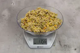 13.56 ounces of ground products from garbage disposal on digital scale on granite-looking table.