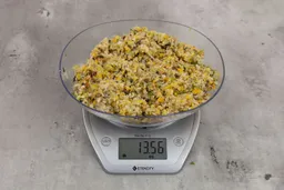13.56 ounces of ground products from garbage disposal on digital scale on granite-looking table.