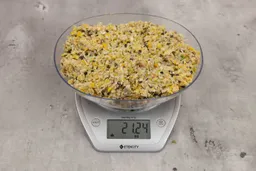 21.24 ounces of ground products from garbage disposal on digital scale on granite-looking table.