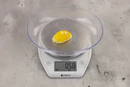 0.58-ounce piece of lemon peel from garbage disposal on digital scale on granite-looking table