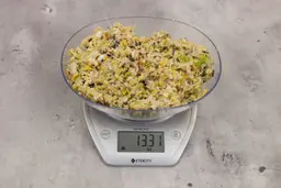13.31 ounces of fish pin bones in mess of assorted scraps from garbage disposal on digital scale on granite-looking top.