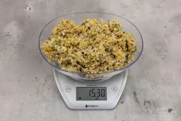 15.3 ounces of ground products from garbage disposal on digital scale on granite-looking table.