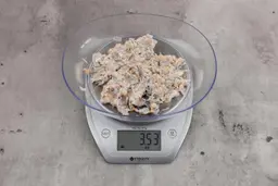 3.53 ounces of ground fish scraps from garbage disposal, displayed on digital scale, placed on granite-looking table. Mess of assorted shredded bones and raw fibrous tissue.