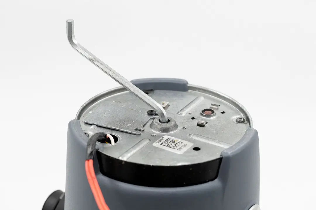 Bottom view of InSinkErator Evolution Compact disposal, showing jam buster wrench in manual unjam slot.