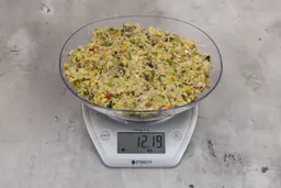 12.19 ounces of fish pin bones in mess of assorted scraps from garbage disposal on digital scale on granite-looking top. 