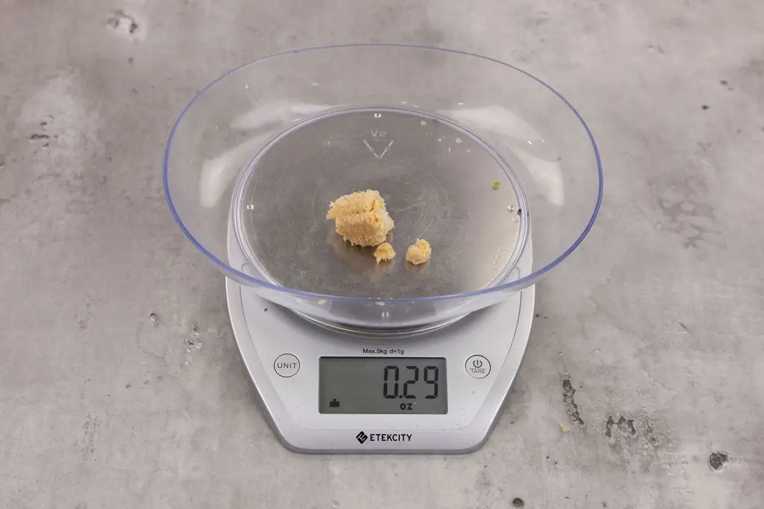 0.29 ounces of ground products from garbage disposal, displayed on digital scale, placed on granite-looking table. Broken up pieces of corncob.