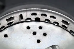 Inside view of Moen Chef Series GX100C garbage disposal, showing design of grater ring and details on flywheel.