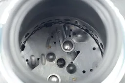 Top view into chamber of Moen Chef Series GX100C garbage disposal after testing, looking at layout of grinding components.