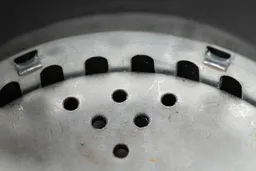 Inside view of Moen Host Series GXS75C garbage disposal, showing design of grater ring and details on flywheel.