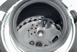 Top view into chamber of Moen Host Series GXS75C garbage disposal after testing, looking at layout of grinding components.