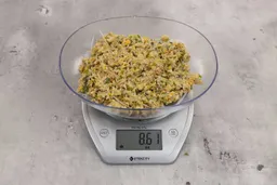 8.61 ounces of visible fish pin bones in mess of ground assorted scraps, on digital scale, on granite-looking top.