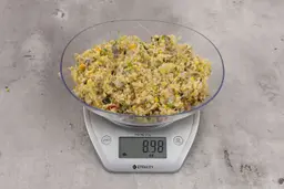 8.98 ounces of assorted scraps from garbage disposal on digital scale on granite-looking top.