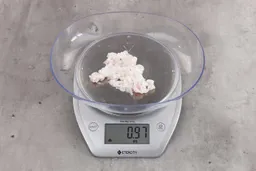 0.97 ounces of soft tissue and pieces of shredded cartilage, on digital scale, on granite-looking table.