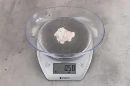 0.58 ounces of shredded soft tissue, on digital scale, on granite-looking table.