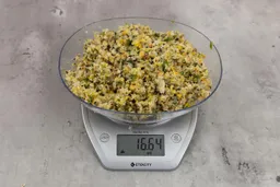 16.64 ounces of assorted ground scraps, including dietary fibers, bones, etc., on digital scale, on granite-looking top.