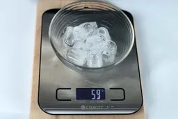 Nine ice bullets in a glass bowl on a scale showing a net weight of 59 grams.