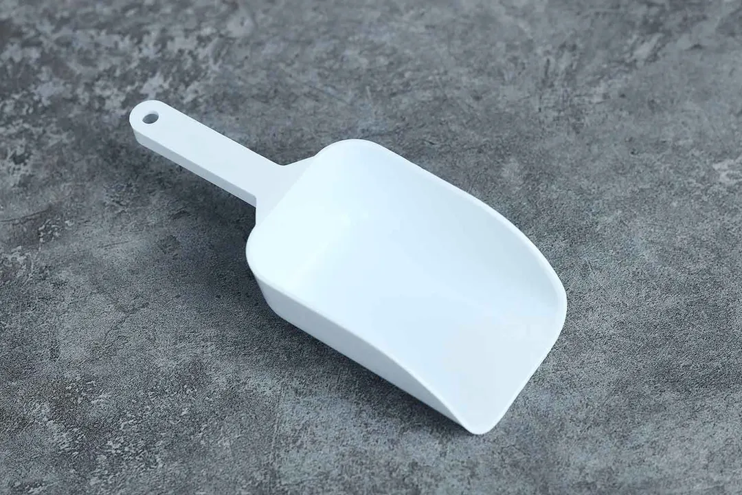 Top down and close up view of a generic ice scooper for a portable countertop ice making machine.