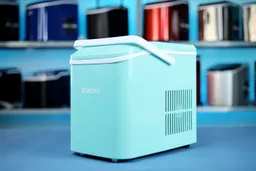 A close up side view of a portable ice maker with two rows of ice makers on a shelf in the background.