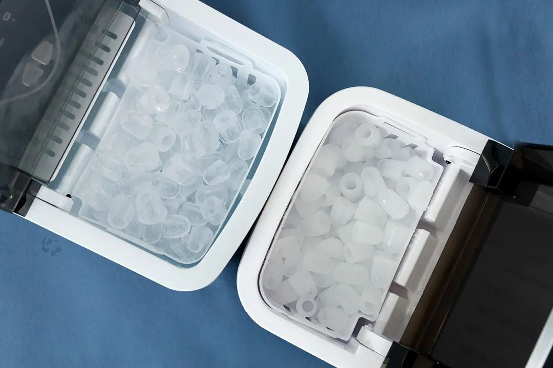 A close up of two countertop ice makers with full baskets of ice. The one to the right has clear ice made from zero TDS water, the one to right has cloudy ice made from tap water.