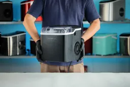 A man is carrying a portable ice maker to place on a table top.