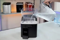 Water being poured in a portable countertop ice maker.