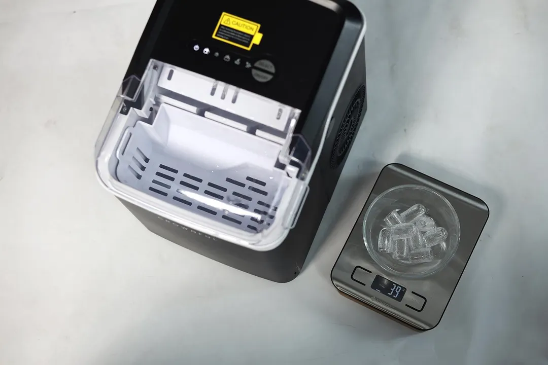 A portable ice maker with a bowl of freshly made ice on a scale showing 39 grams in total.