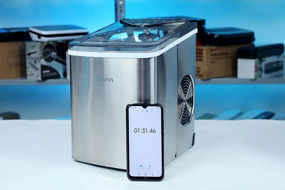 A portable countertop ice maker with a timer counting how long one ice making session takes.