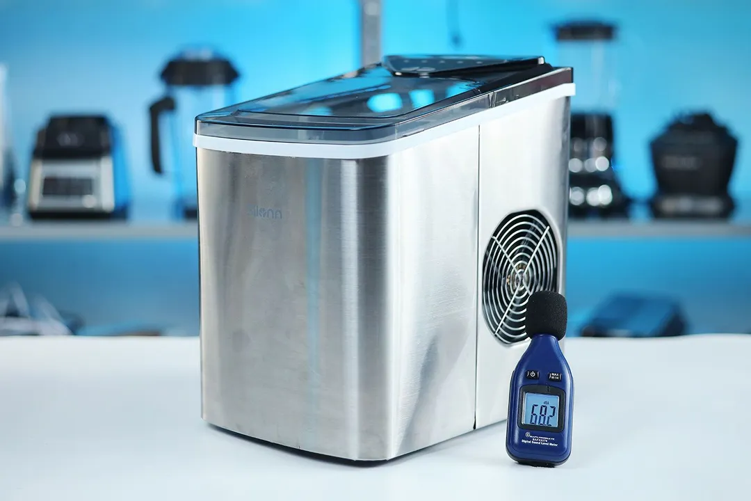 A decibel meter measuring the noise being produced by the fan on a working countertop portable bullet ice maker.