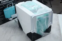 A portable ice maker just removed from its box and secured within styrofoam pads.