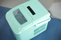 A top down view of a countertop ice maker with ice seen through the transparent lid