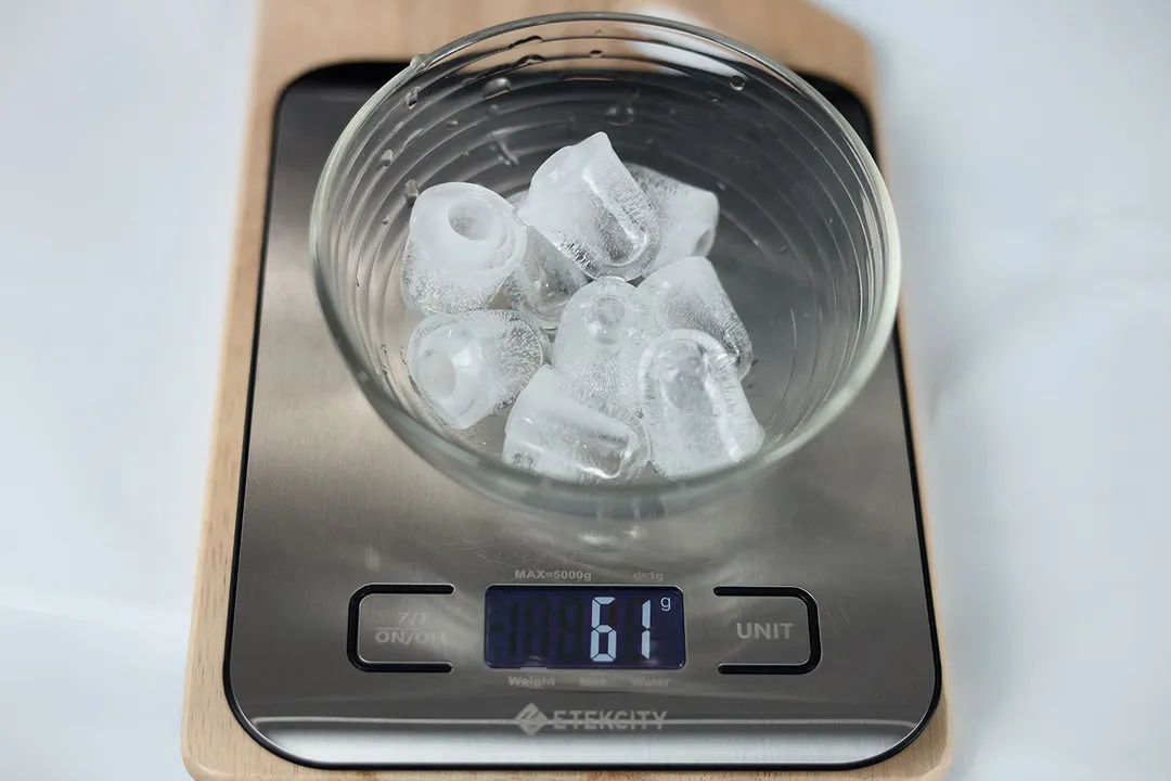 Nine ice bullets, from one cycle of ice-making from a typical countertop ice maker, in  a glass bowl on a scale showing a net weight of  61 grams.