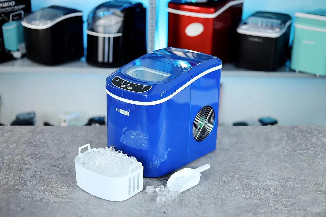 The Vivo Home countertop ice maker with a full basket of ice in front and the ice scoop to the side with ice bullets scooped inside.
